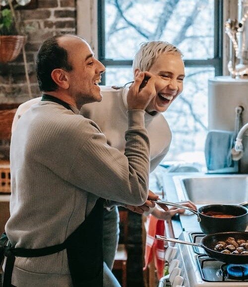 two people having fun while cooking